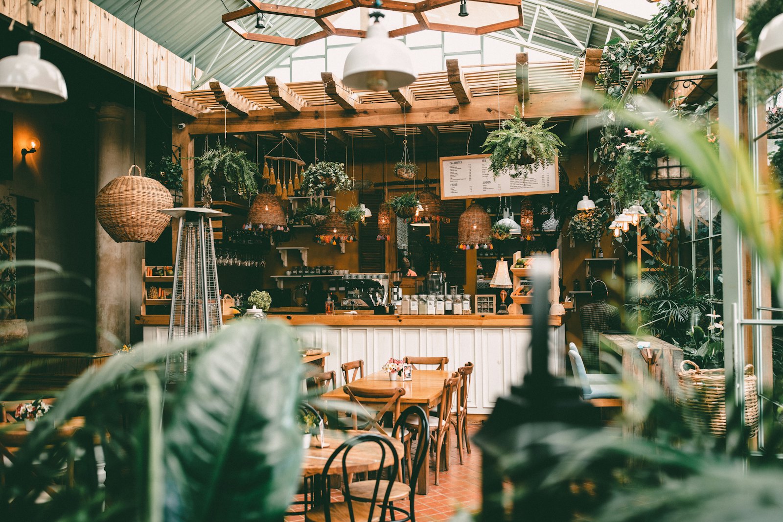 Sample photo: a sunlit café dining room under a glass roof, full of plants